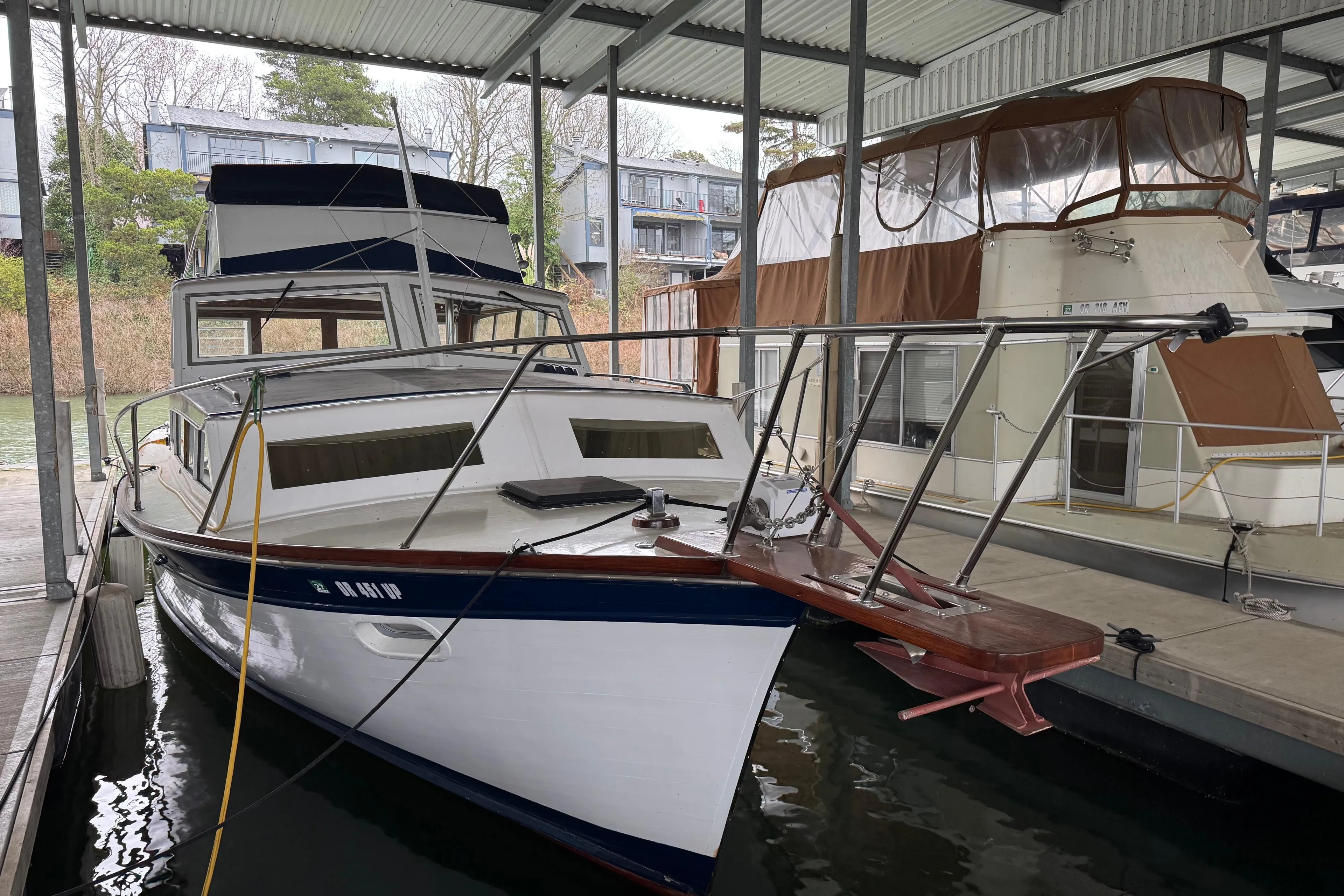 1967 Pacemaker 37 boat docked in a covered marina, surrounded by other vessels.
