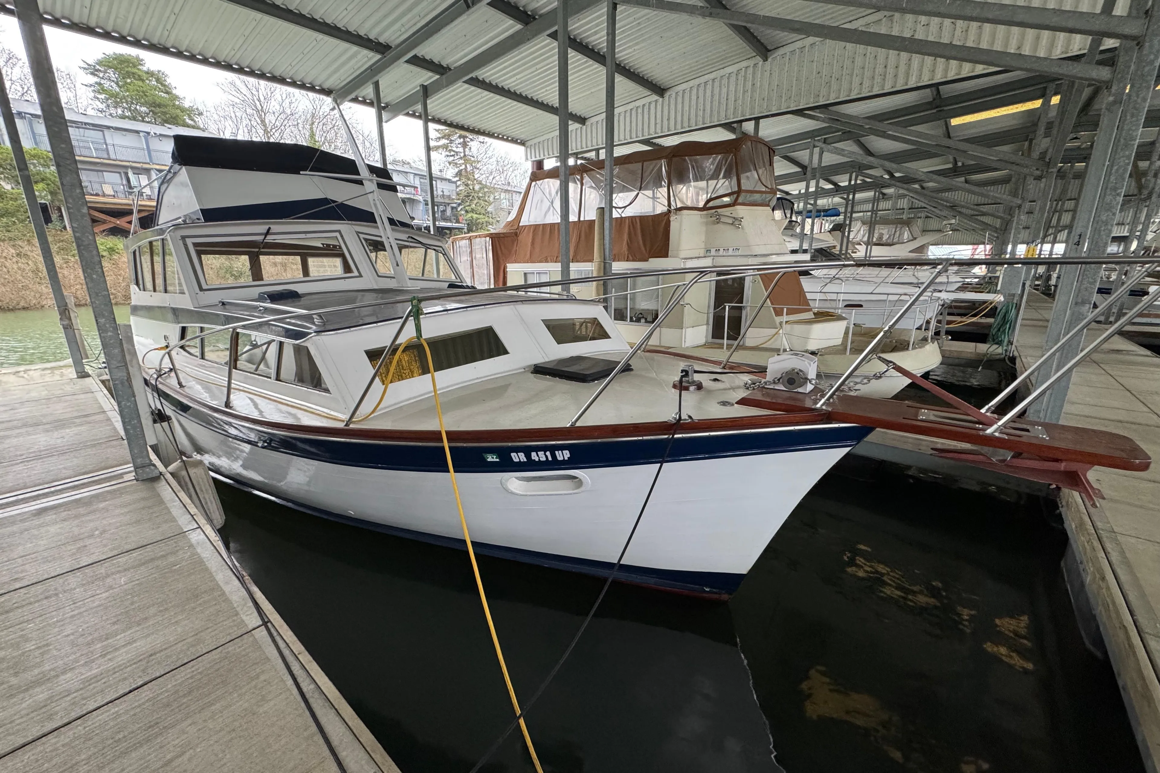 1967 Pacemaker 37 boat docked in a covered marina, showcasing classic design.