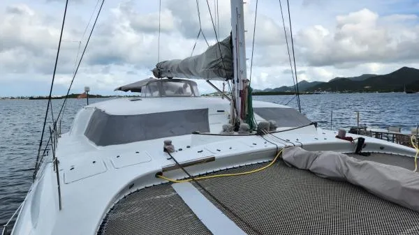 Fat Cat Yacht Photos Pics Sailing yacht on water, Custom Morelli-Miller 1991, with cloudy sky and distant mountains.