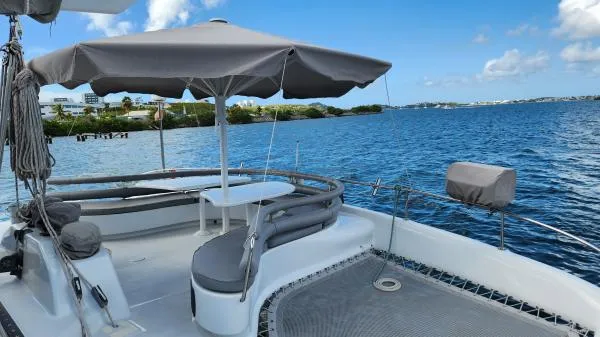 Fat Cat Yacht Photos Pics Deck of 1991 Custom Morelli-Miller boat with umbrella, overlooking serene blue waters.