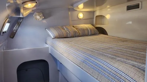 Fat Cat Yacht Photos Pics Cozy cabin interior of 1991 Custom Morelli-Miller with striped bedding and ambient lighting.