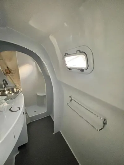 Fat Cat Yacht Photos Pics Compact bathroom interior of 1991 Custom Morelli-Miller with porthole window and stainless steel sink.