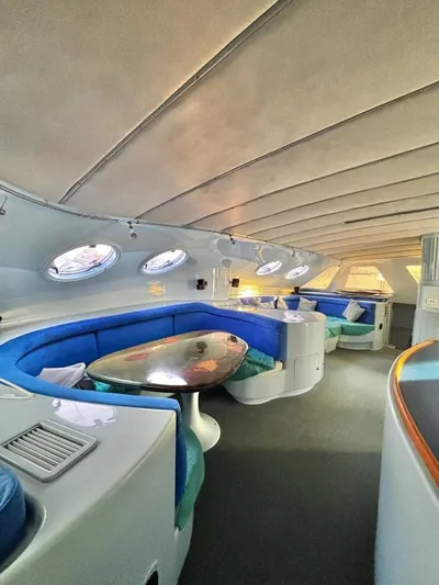 Fat Cat Yacht Photos Pics Luxurious 1991 Custom Morelli-Miller yacht interior with blue seating and oval windows.