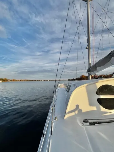 Fat Cat Yacht Photos Pics Sailboat on calm water, Custom Morelli-Miller 1991, under a partly cloudy sky.
