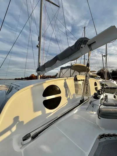 Fat Cat Yacht Photos Pics Sailboat deck of 1991 Custom Morelli-Miller, featuring sleek design and rigging against a cloudy sky.