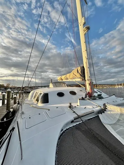 Fat Cat Yacht Photos Pics Sailboat docked at marina, Custom Morelli-Miller 1991, under a cloudy sky.