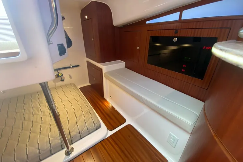  Yacht Photos Pics 2018 Pursuit OS 385 Offshore cabin interior with wood accents and cushioned seating.