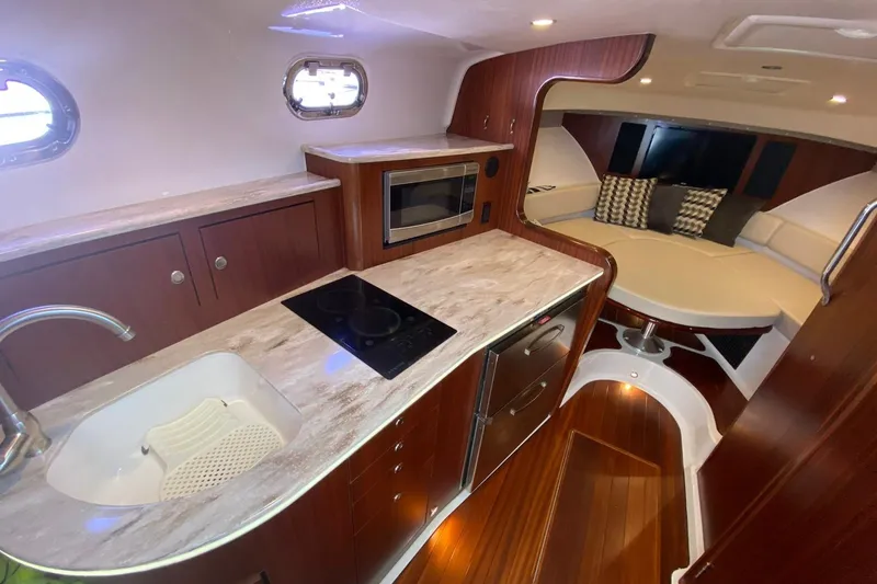  Yacht Photos Pics 2018 Pursuit OS 385 Offshore yacht interior with kitchen, seating area, and modern amenities.