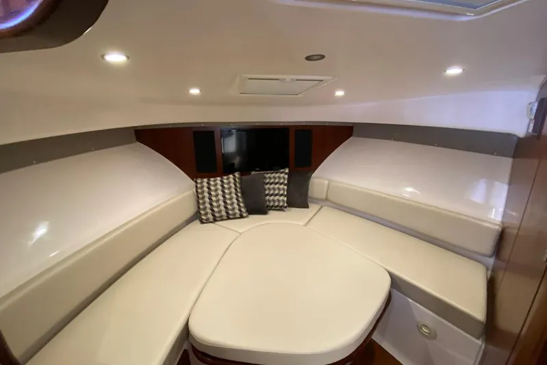  Yacht Photos Pics 2018 Pursuit OS 385 Offshore cabin interior with cushioned seating and modern lighting.
