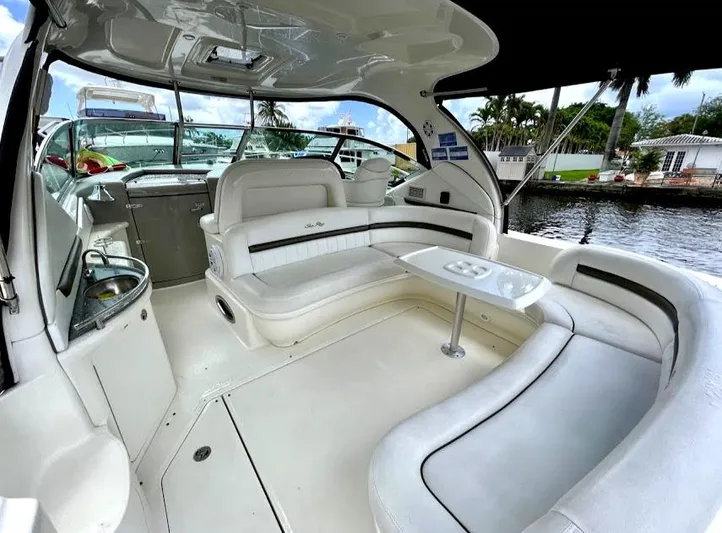  Yacht Photos Pics 2007 Sea Ray 44 Sundancer yacht interior with white seating and table, docked by waterfront homes.