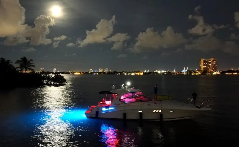  Yacht Photos Pics 2007 Sea Ray 44 Sundancer yacht illuminated at night on a moonlit waterway.