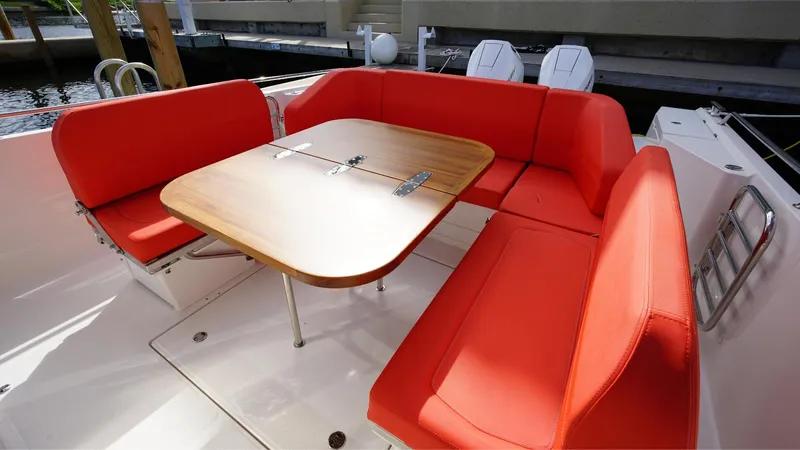 In-stock 2024 Nimbus T11 #260 Yacht Photos Pics 2024 Nimbus Tender 11 #260 boat with vibrant red seating and wooden table.