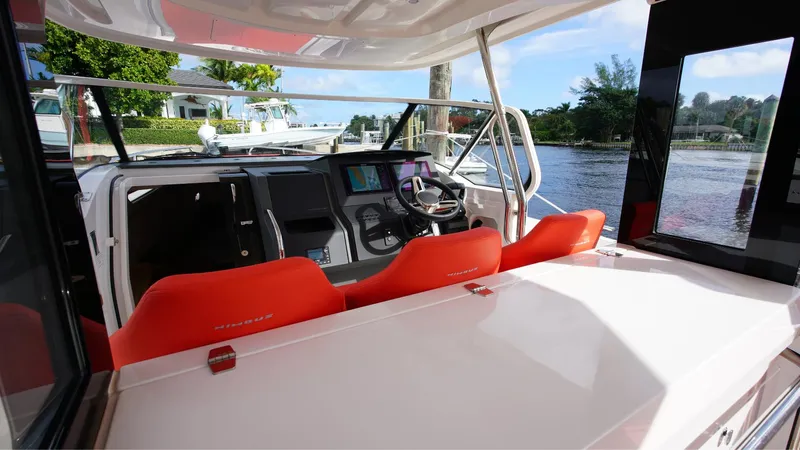 In-stock 2024 Nimbus T11 #260 Yacht Photos Pics 2024 Nimbus Tender 11 #260 boat interior with red seating and modern dashboard.