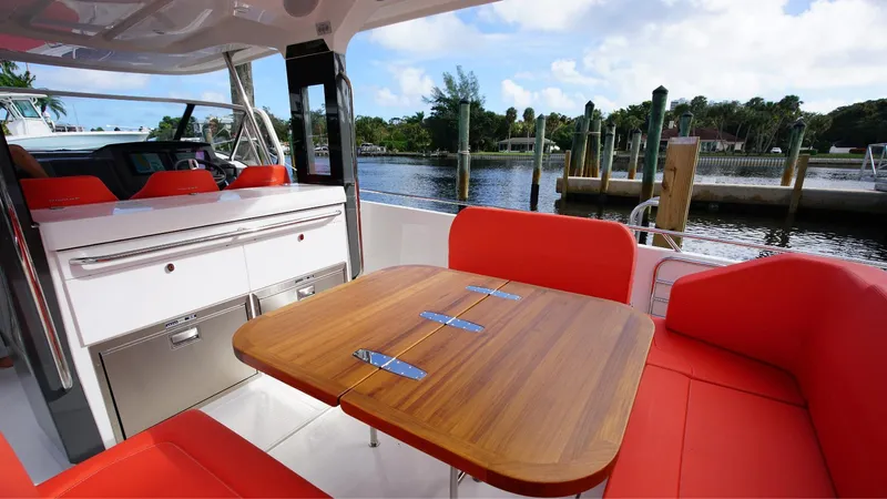 In-stock 2024 Nimbus T11 #260 Yacht Photos Pics Luxurious 2024 Nimbus Tender 11 boat interior with red seating and wooden table.