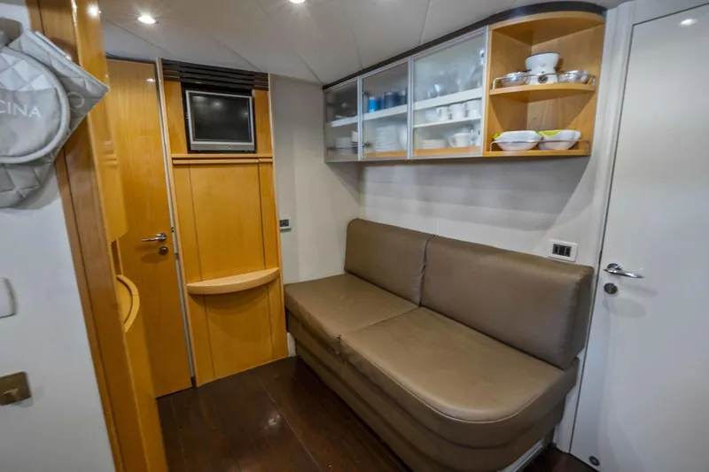 Denise Yacht Photos Pics Interior of 2005 Pershing 76 Motor Yacht with sofa, TV, and storage cabinets.