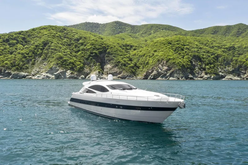 Denise Yacht Photos Pics 2005 Pershing 76 Motor Yacht cruising near lush green hills.