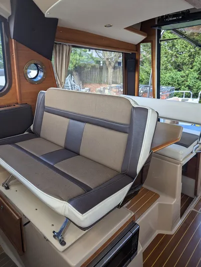  Yacht Photos Pics Interior of 2017 Ranger Tugs R-298 with cushioned seating and wooden flooring.
