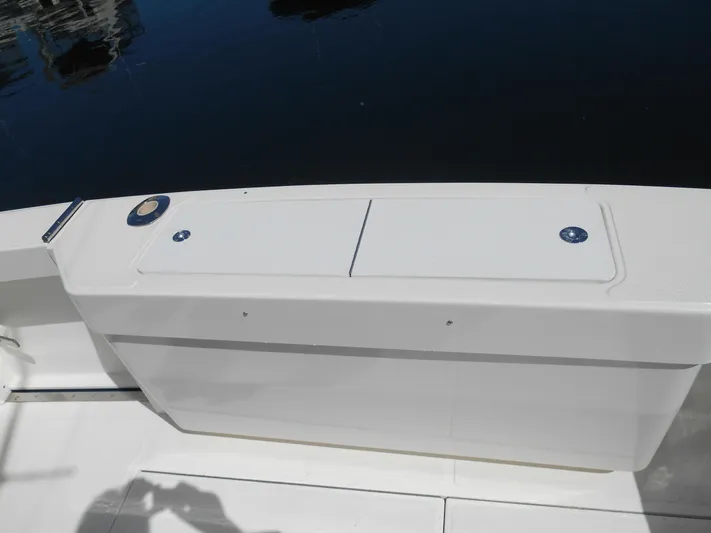 Mistress Yacht Photos Pics 1998 Cabo 31 Express boat deck with storage compartments, docked on calm water.