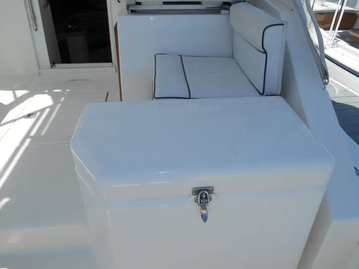 Mistress Yacht Photos Pics 1998 Cabo 31 Express boat interior with cushioned seating and storage compartment.