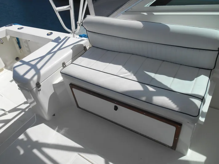Mistress Yacht Photos Pics White cushioned seating on 1998 Cabo 31 Express boat deck, with storage compartment.