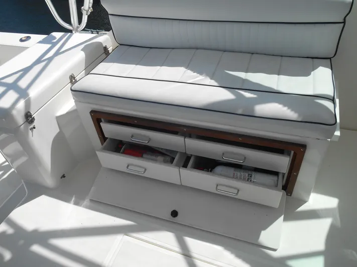 Mistress Yacht Photos Pics White cushioned bench with storage drawers on a 1998 Cabo 31 Express boat.