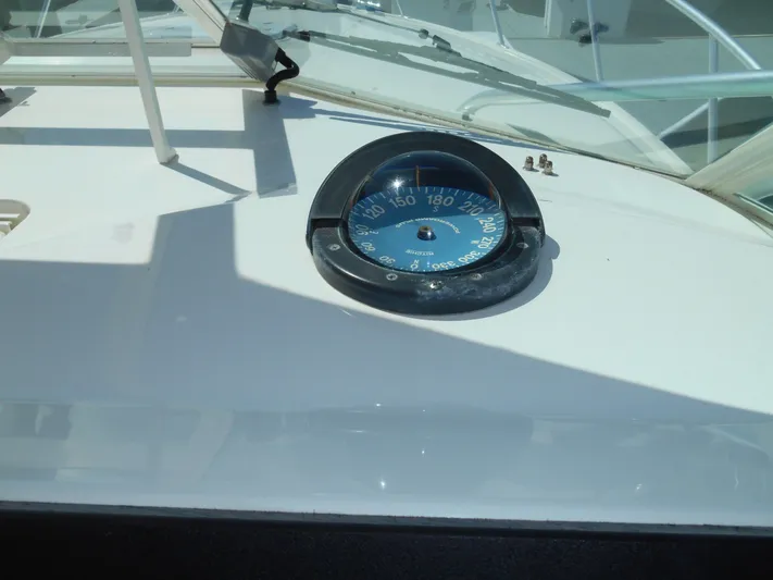 Mistress Yacht Photos Pics Compass on 1998 Cabo 31 Express boat dashboard in sunlight.