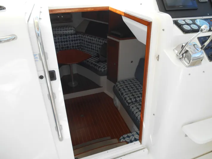 Mistress Yacht Photos Pics Interior view of a 1998 Cabo 31 Express boat, featuring seating and a small table.