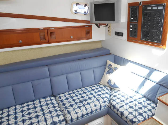 Mistress Yacht Photos Pics Interior of a 1998 Cabo 31 Express boat with blue seating and nautical decor.