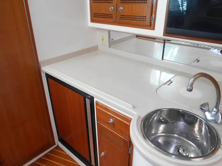 Mistress Yacht Photos Pics 1998 Cabo 31 Express boat interior with sink, countertop, and wooden cabinets.