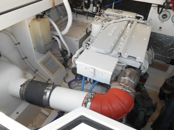 Mistress Yacht Photos Pics Engine compartment of a 1998 Cabo 31 Express boat, showcasing mechanical components and piping.