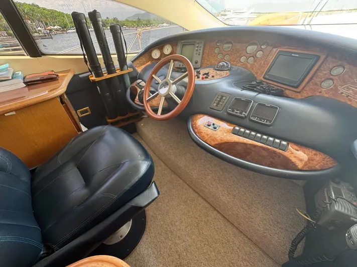 Stella Mia Yacht Photos Pics Luxurious 2001 Azimut 68 Plus yacht cockpit with leather seating and wooden dashboard.