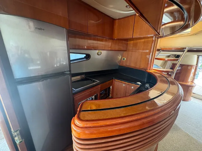 Stella Mia Yacht Photos Pics Luxurious kitchen interior of 2001 Azimut 68 Plus yacht with wood finish and modern appliances.