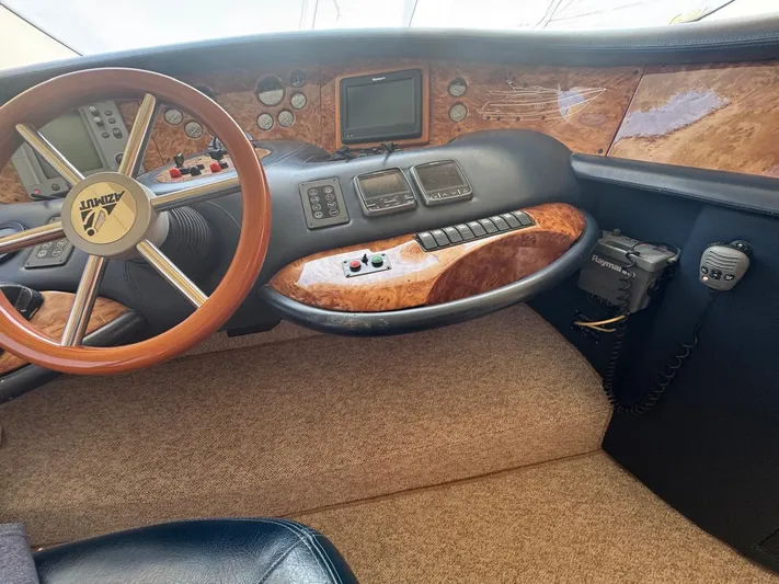 Stella Mia Yacht Photos Pics Interior of 2001 Azimut 68 Plus yacht cockpit with wooden steering wheel and control panel.