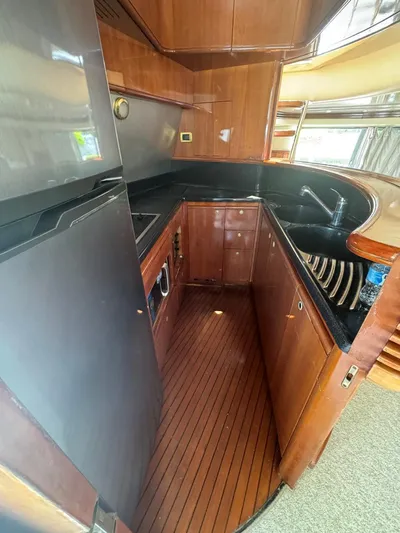 Stella Mia Yacht Photos Pics Luxurious kitchen interior of 2001 Azimut 68 Plus yacht with wood cabinetry and modern appliances.