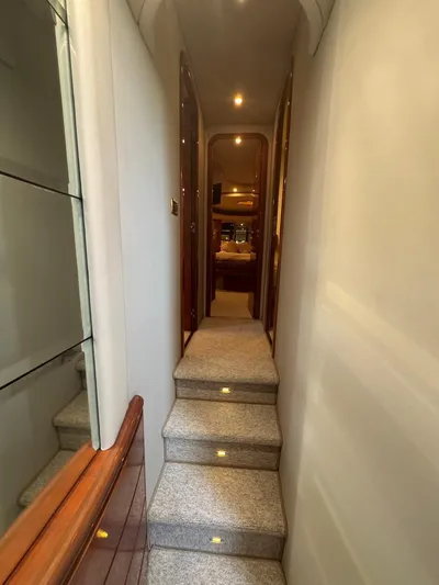 Stella Mia Yacht Photos Pics Interior hallway of 2001 Azimut 68 Plus yacht with carpeted stairs and wooden accents.