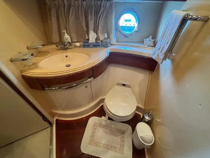 Stella Mia Yacht Photos Pics Luxurious bathroom in 2001 Azimut 68 Plus yacht with elegant fixtures and porthole window.