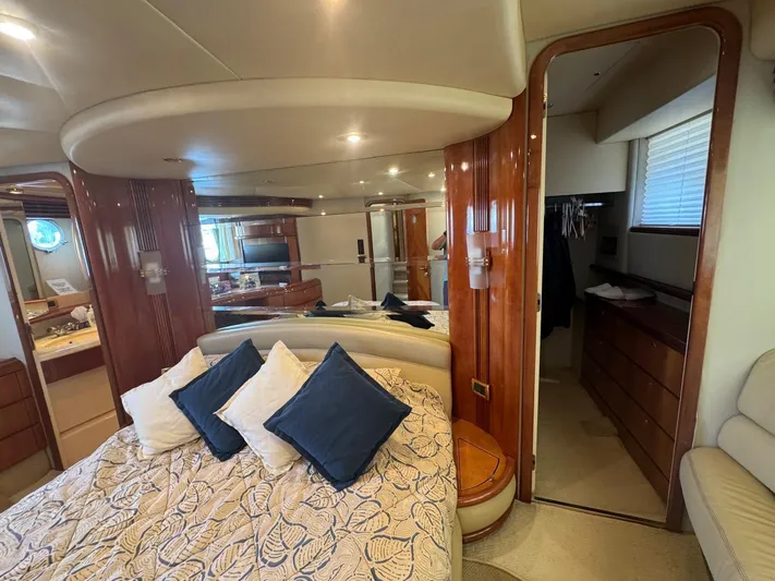 Stella Mia Yacht Photos Pics Luxurious bedroom interior of a 2001 Azimut 68 Plus yacht with elegant wood finishes.