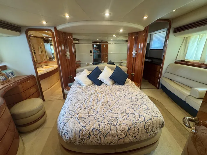 Stella Mia Yacht Photos Pics Luxurious bedroom interior of 2001 Azimut 68 Plus yacht with elegant wood finishes.