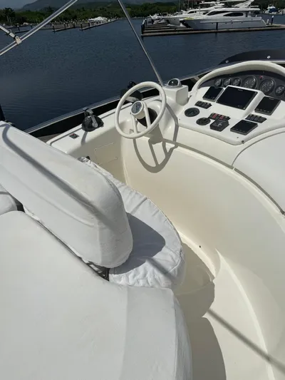 Stella Mia Yacht Photos Pics Helm of 2001 Azimut 68 Plus yacht with white seating and control panel.