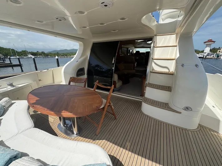 Stella Mia Yacht Photos Pics Luxurious 2001 Azimut 68 Plus yacht deck with wooden table and seating area.