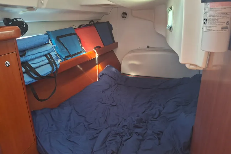 H2o Bungalow Yacht Photos Pics Cozy cabin interior of 2006 Beneteau Oceanis 393 sailboat with blue bedding and storage.