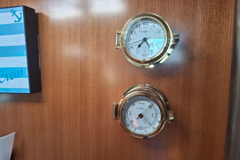 H2o Bungalow Yacht Photos Pics Brass clock and barometer on Beneteau Oceanis 393 yacht's wooden interior wall.