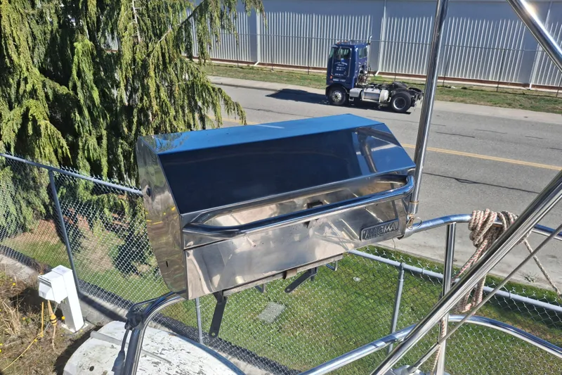 H2o Bungalow Yacht Photos Pics Stainless steel grill on a 2006 Beneteau Oceanis 393 sailboat, near a road and greenery.