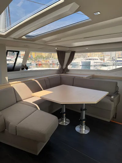 Fp Tanna 47 Yacht Photos Pics 2024 Fountaine Pajot Tanna 47 interior with skylight, modern seating, and marina view.
