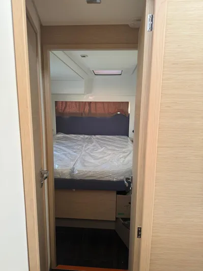 Fp Tanna 47 Yacht Photos Pics 2024 Fountaine Pajot Tanna 47 cabin interior with bed and wooden door.
