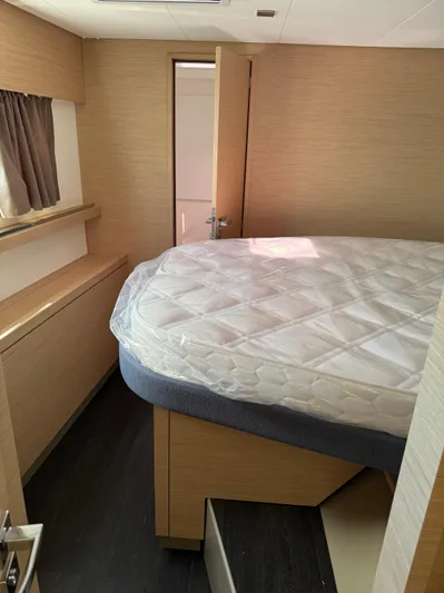 Fp Tanna 47 Yacht Photos Pics 2024 Fountaine Pajot Tanna 47 cabin interior with bed and wooden accents.