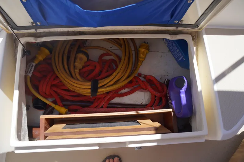 Midnight Yacht Photos Pics Storage compartment on a 2005 Sabre 386 boat with cables and equipment.