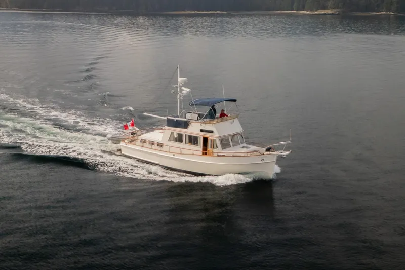 Yacht Photos Pics 1989 Grand Banks 42 yacht cruising on calm waters with Canadian flag.