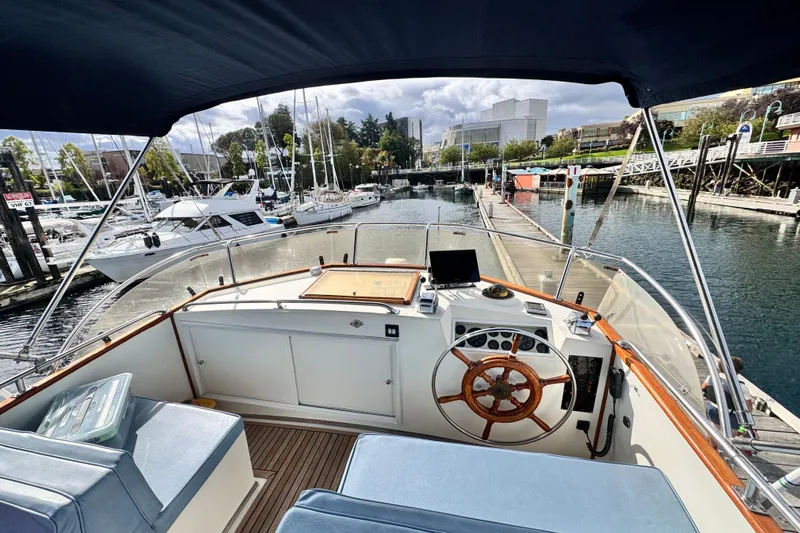  Yacht Photos Pics 1989 Grand Banks 42 yacht helm with wooden wheel, docked in a marina.