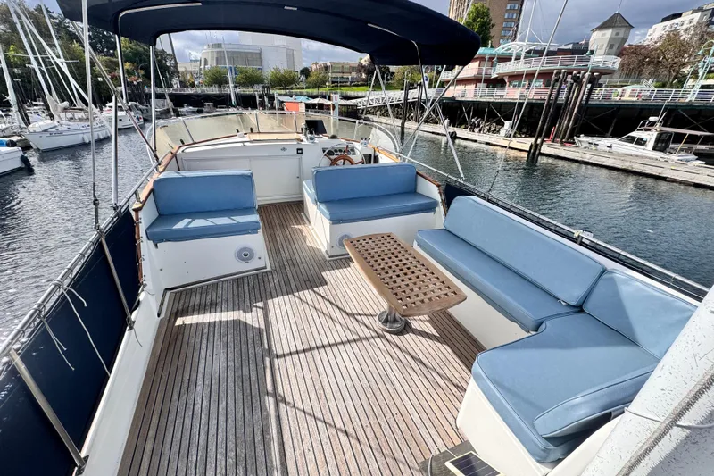  Yacht Photos Pics Spacious deck of 1989 Grand Banks 42 yacht with blue seating and wooden flooring.